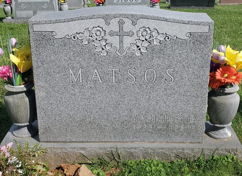 Double headstone featuring carved floral cross design