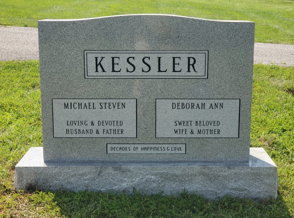 Granite double headstone featuring simple border and shared surname