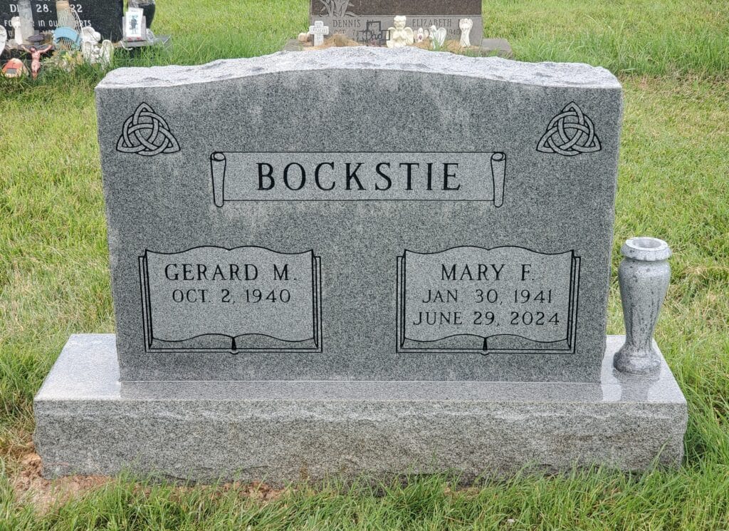 Granite double headstone featuring simple panels and Trinity Knot